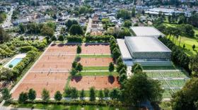 vue aérienne du site du Sporting au coeur de la ville de Vichy. Piscine extérieur à gauche, 6 terrains de tennis en terre battue extérieurs, 6 postes de padel en herbe en extérieur et deux bâtiments