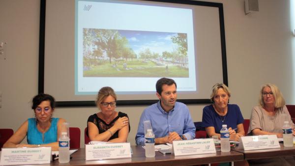 un bureau devant un écran projetant une vue du futur projet de rénovation du quartier de Presles. Sont assis devant 4 femmes et un homme au centre. 