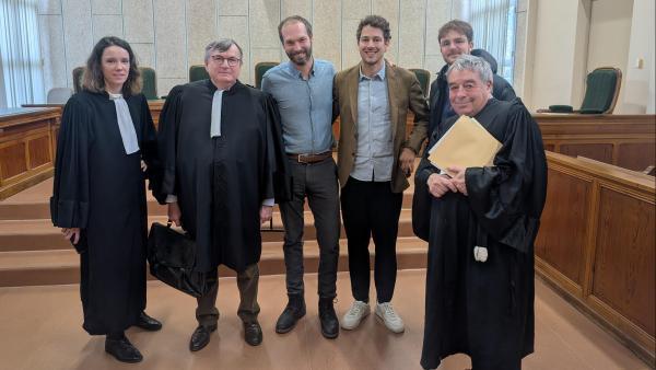 Les dirigeants des deux entreprises au milieu de 3 avocats et un représentant du personnel, dans une salle de tribunal